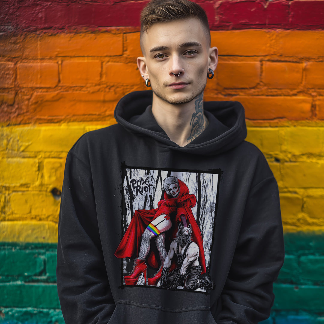 Person wearing a black hoodie with a graphic design in front of a rainbow-colored brick wall.