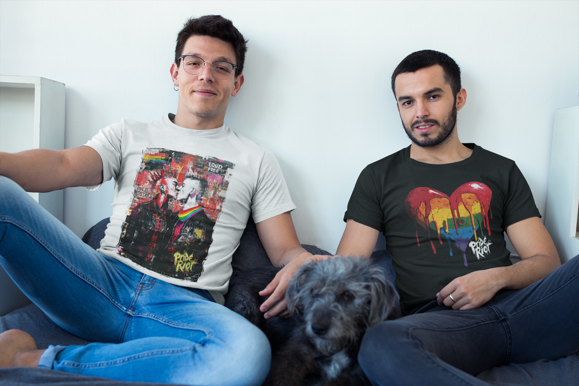 Two men sitting on a couch with a dog, wearing t-shirts with colorful designs.