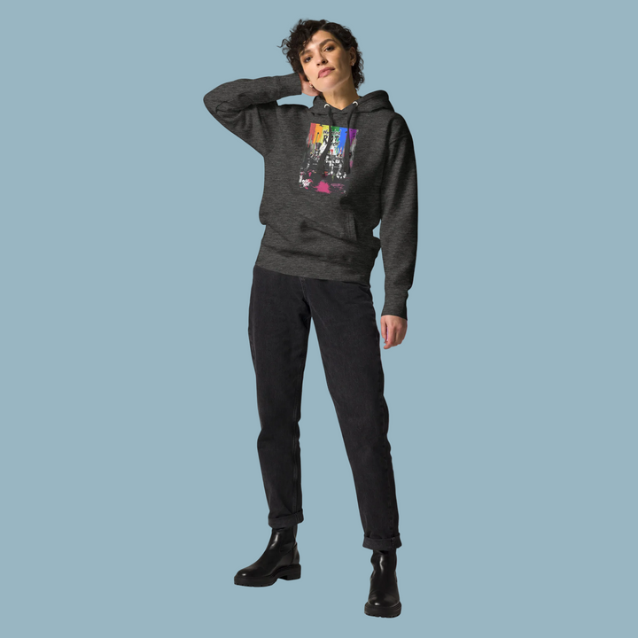 A model walking down a city street wearing the Alice in Anarchy hoodie in Charcoal Heather, paired with baggy cargo pants. The hoodie has a relaxed, boxy drape that does not cling to the body, demonstrating the gender-neutral fit.