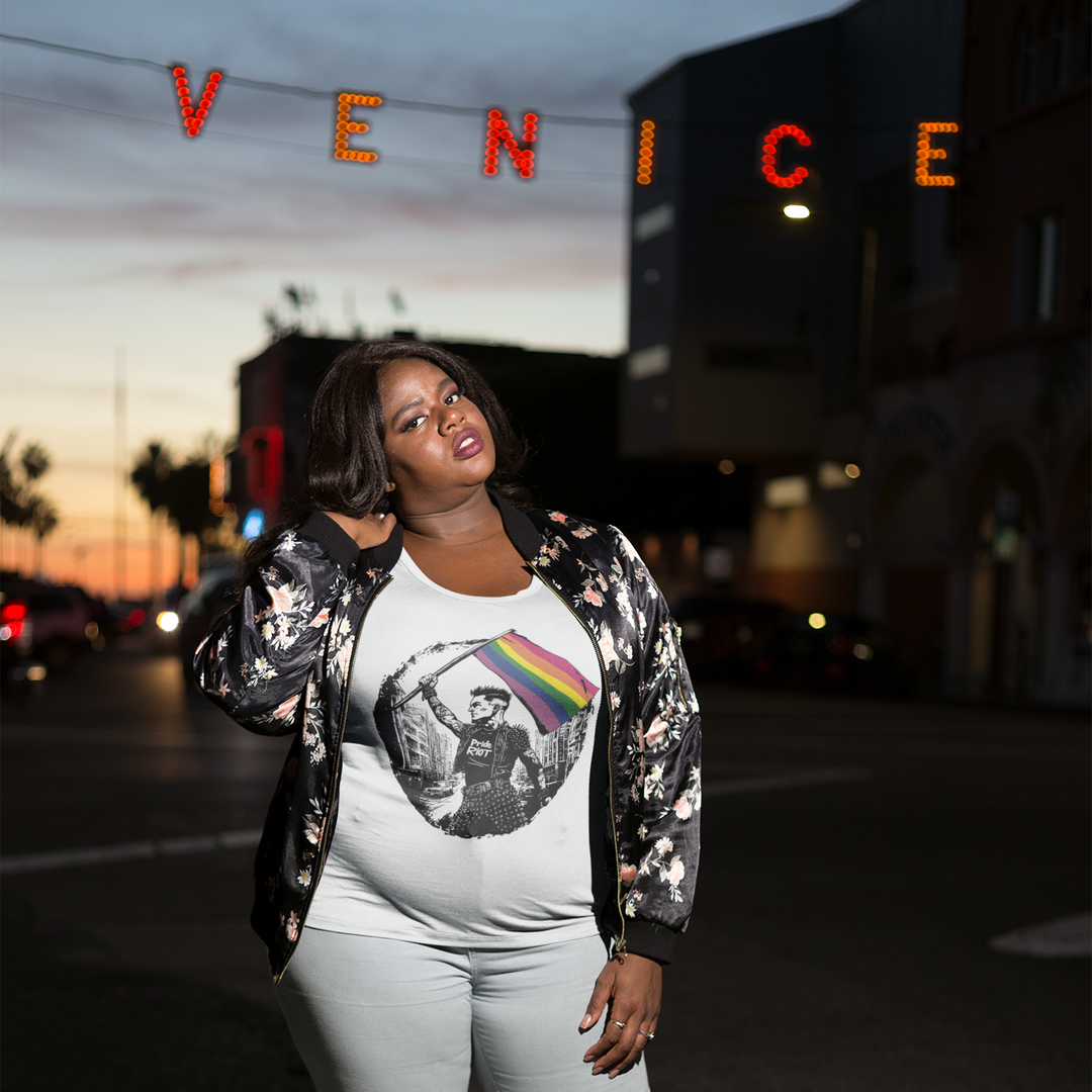 Front view of a white t-shirt featuring the classic 6-stripe Gay Pride rainbow flag. The flag is waving but features a digital glitch effect, giving it a distorted, modern gothic look.