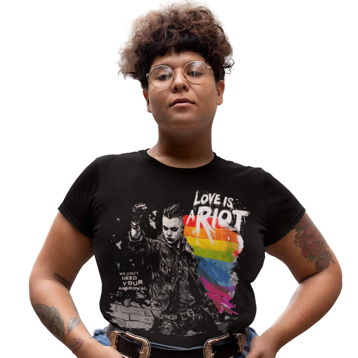 Love is a Riot (Dark) tee worn by a model, black — LOVE IS A RIOT lettering over a rainbow paint splash — Pride Riot
