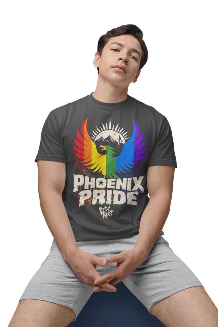 PHX Pride tee in dark grey heather, worn seated, front — rainbow phoenix rising, Pride Riot®