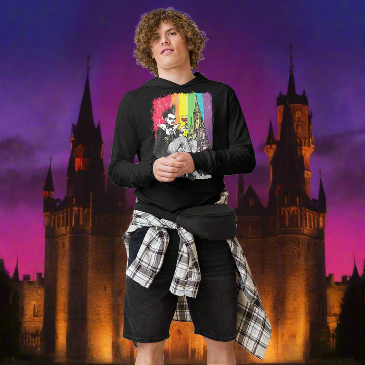 Person wearing a black sweatshirt with a colorful graphic and plaid shirt over black shorts on a white background